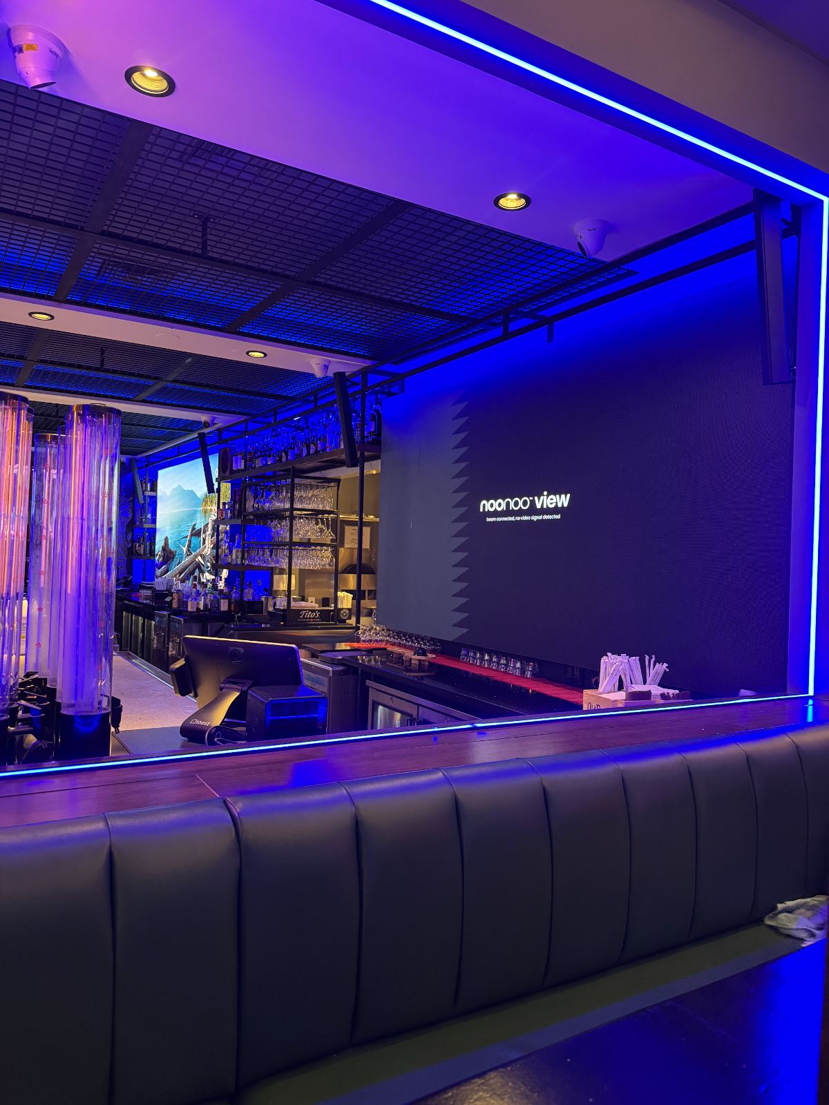 The bar's screens and cove lighting from the far end of the room