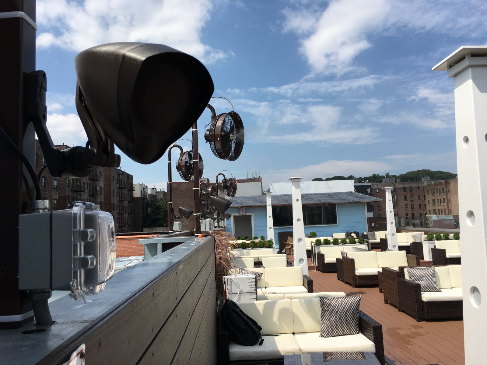 A weatherproof speaker on a rooftop terrace overlooking the city