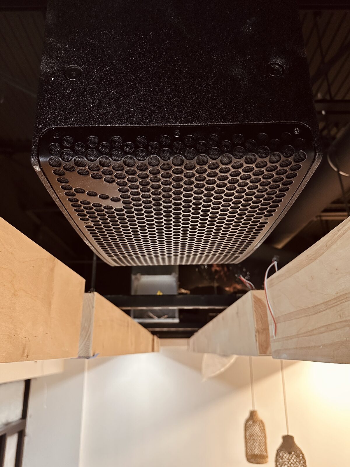 An architectural speaker set into the slatted wood ceiling