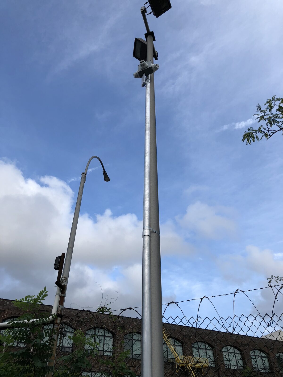 A camera mounted at the top of a lot light pole