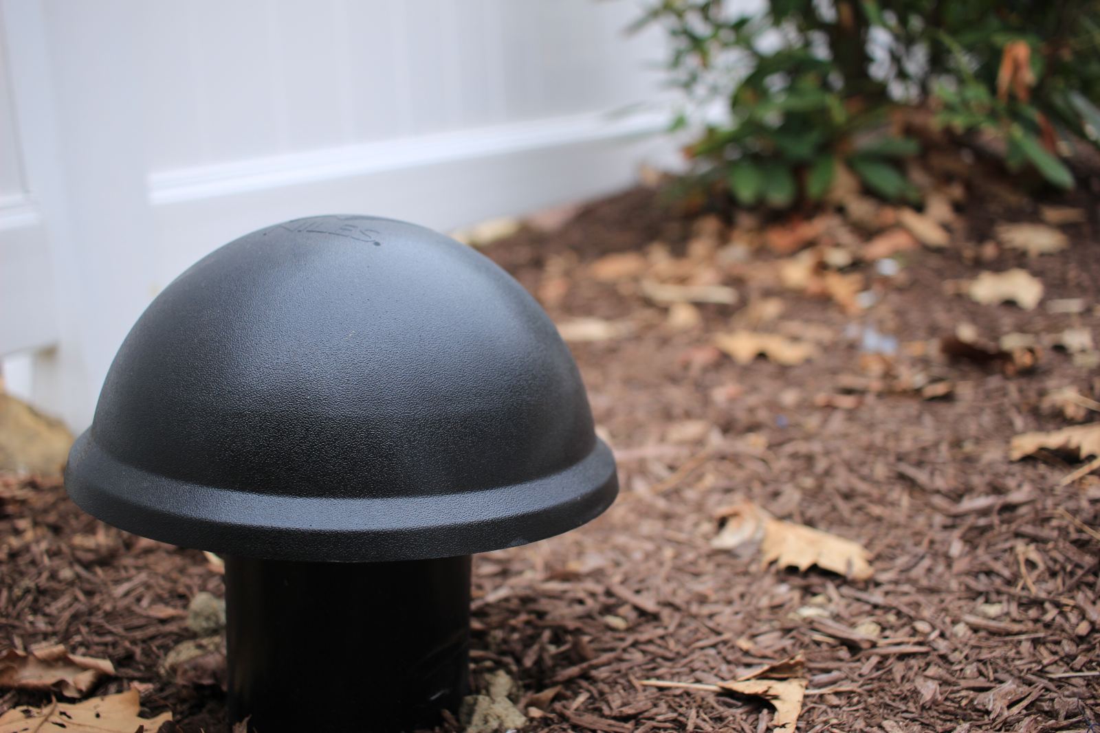 A buried subwoofer dome set into the mulch