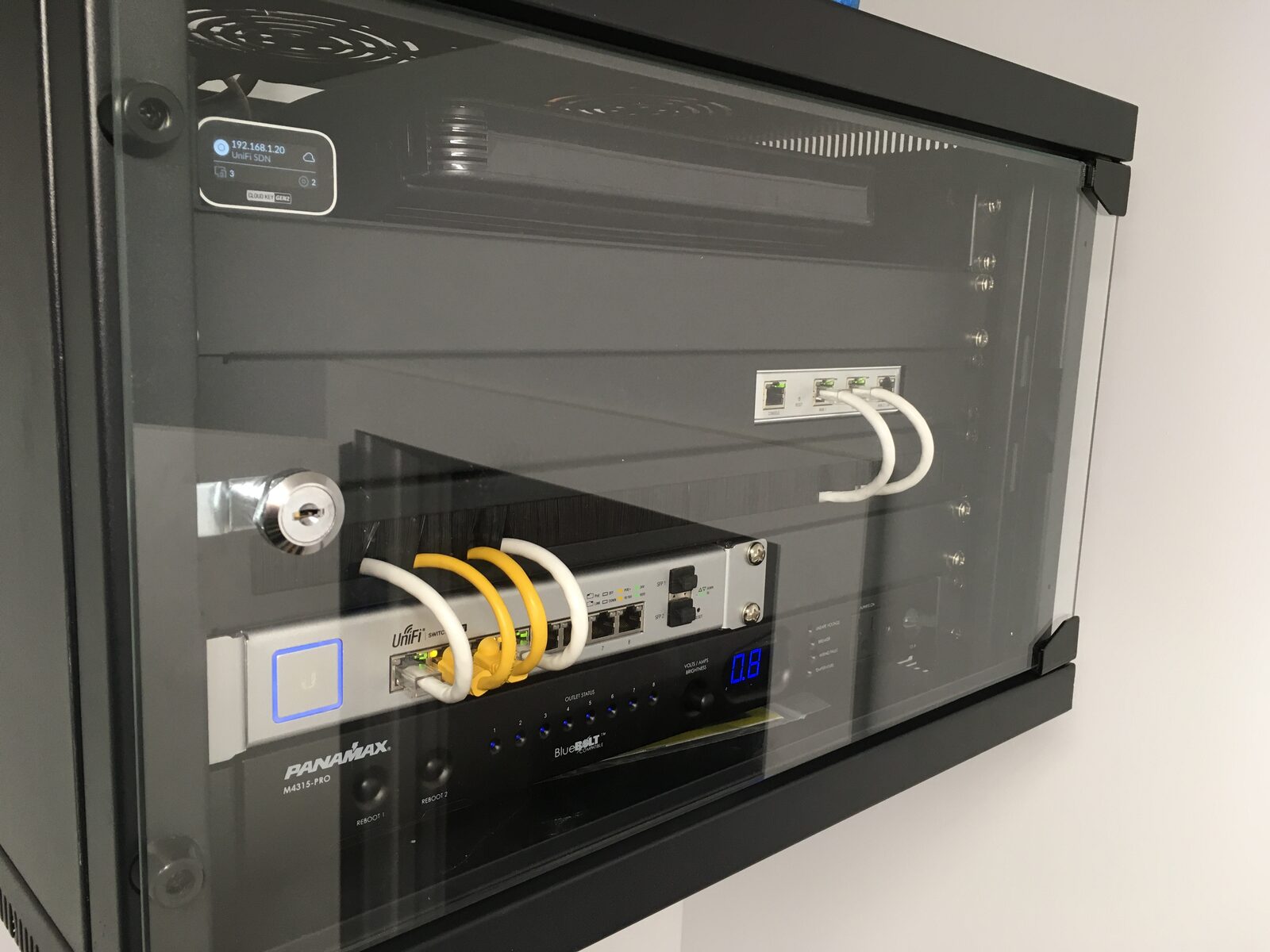 A wall-mounted rack behind glass, patched in yellow