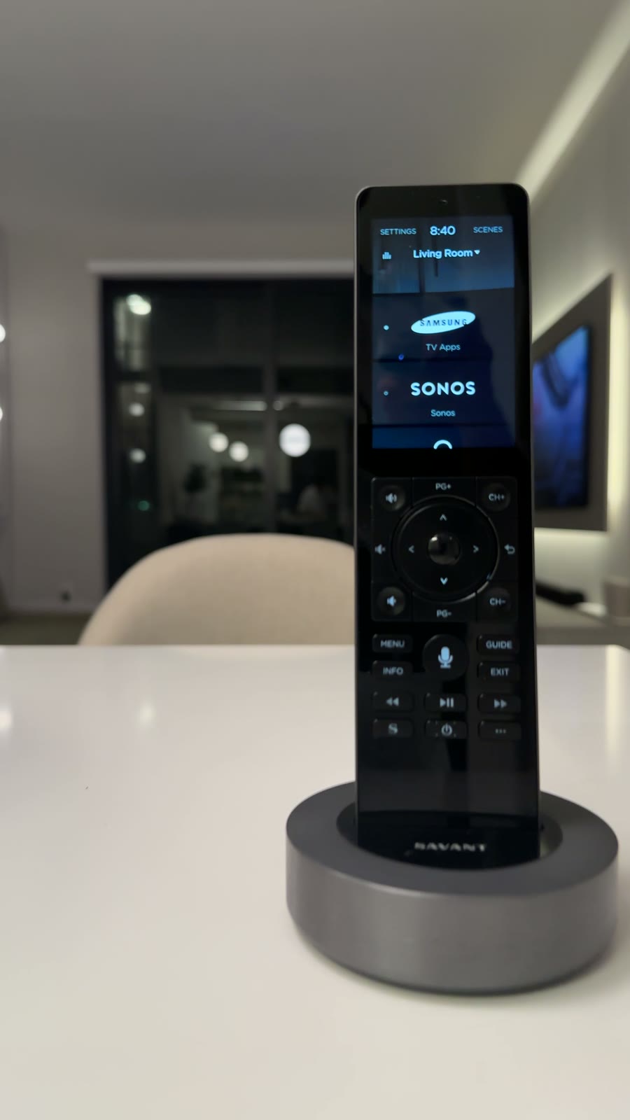 A Savant remote resting in its charging dock on a kitchen counter
