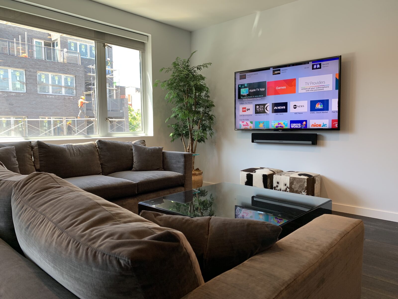 A living room display and soundbar against a city window