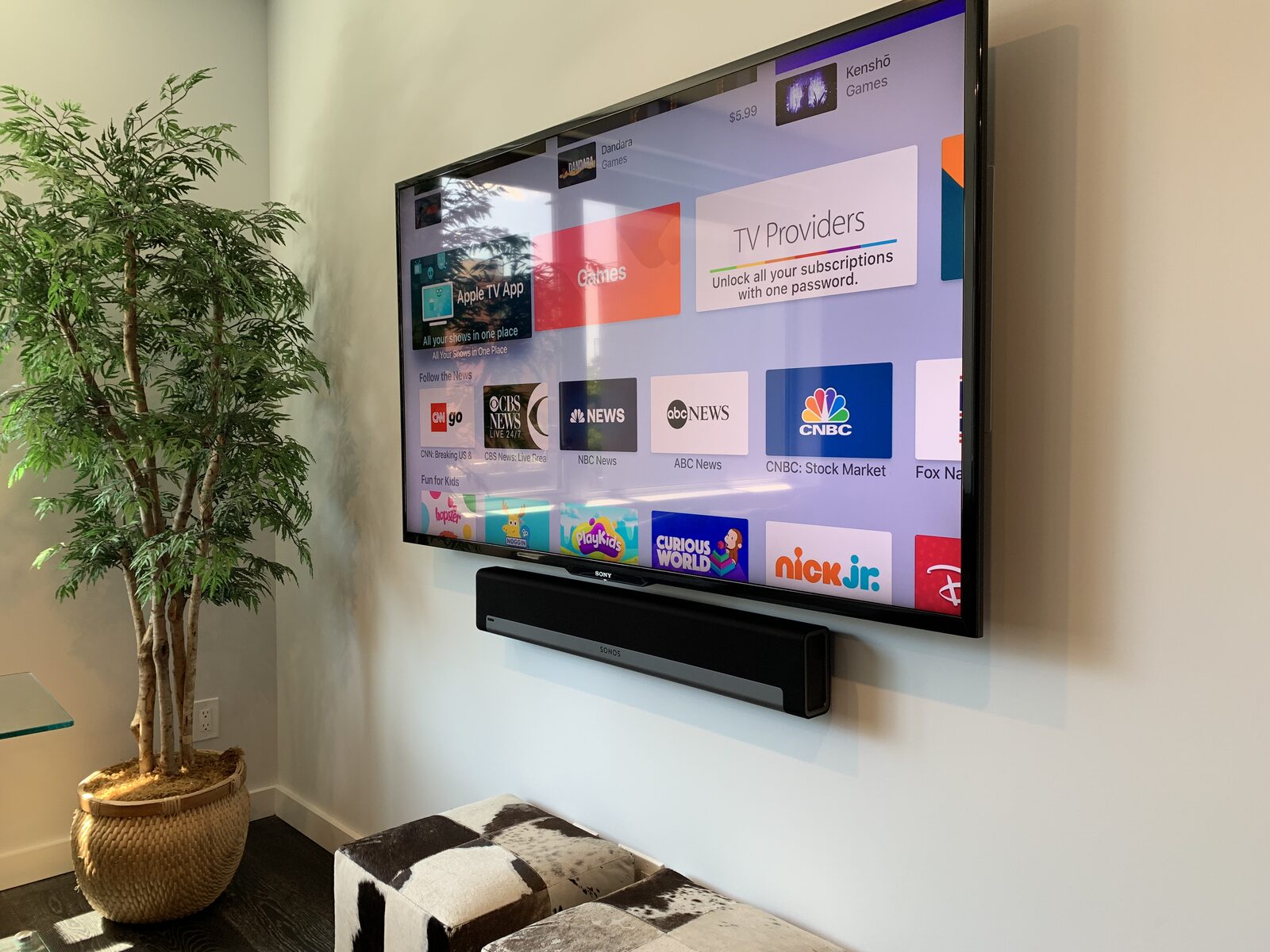 A wall-mounted display and soundbar beside the seating
